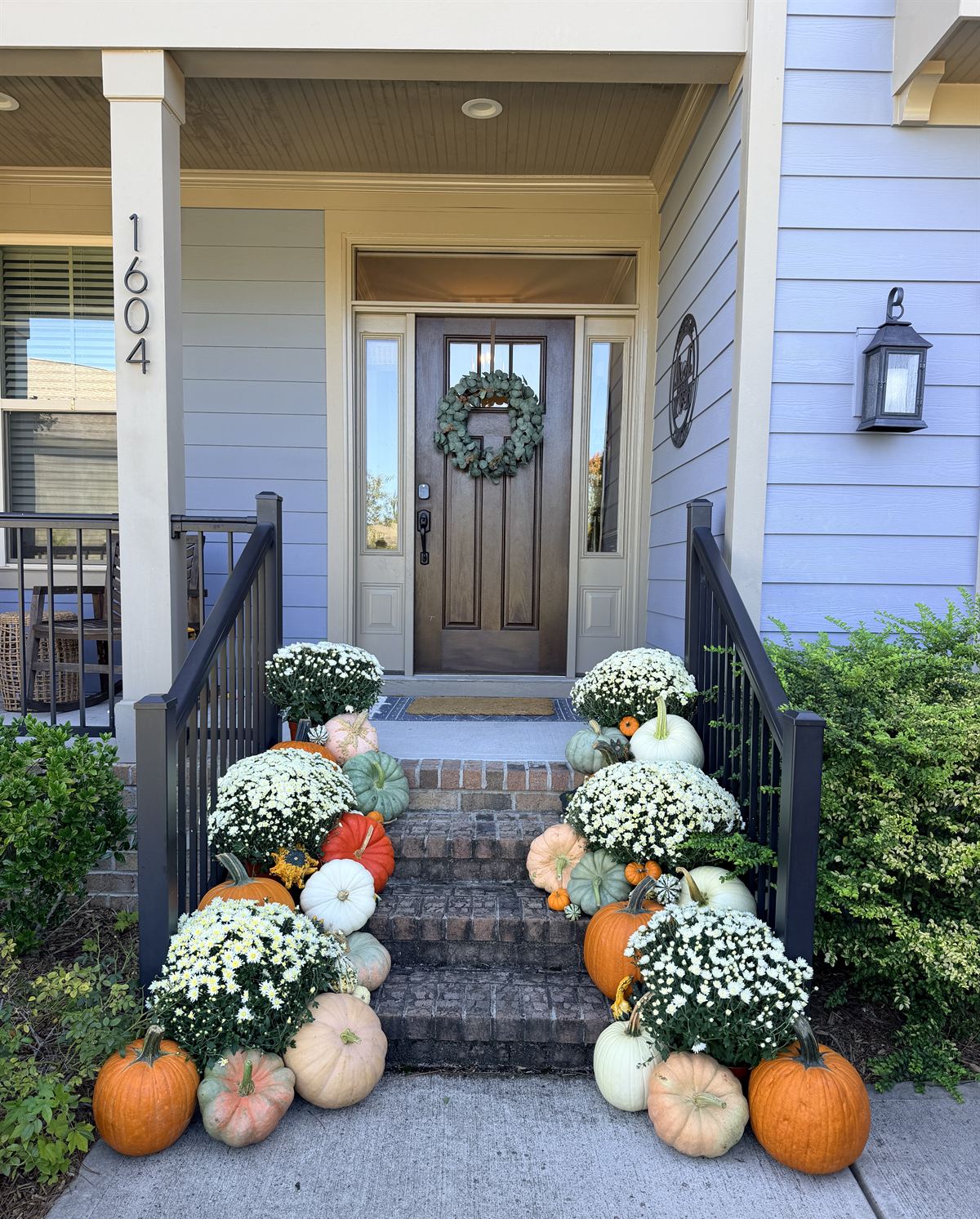 Front steps lined with white mums and heirloom pumpkins in orange, blush and sage, Raleigh NC