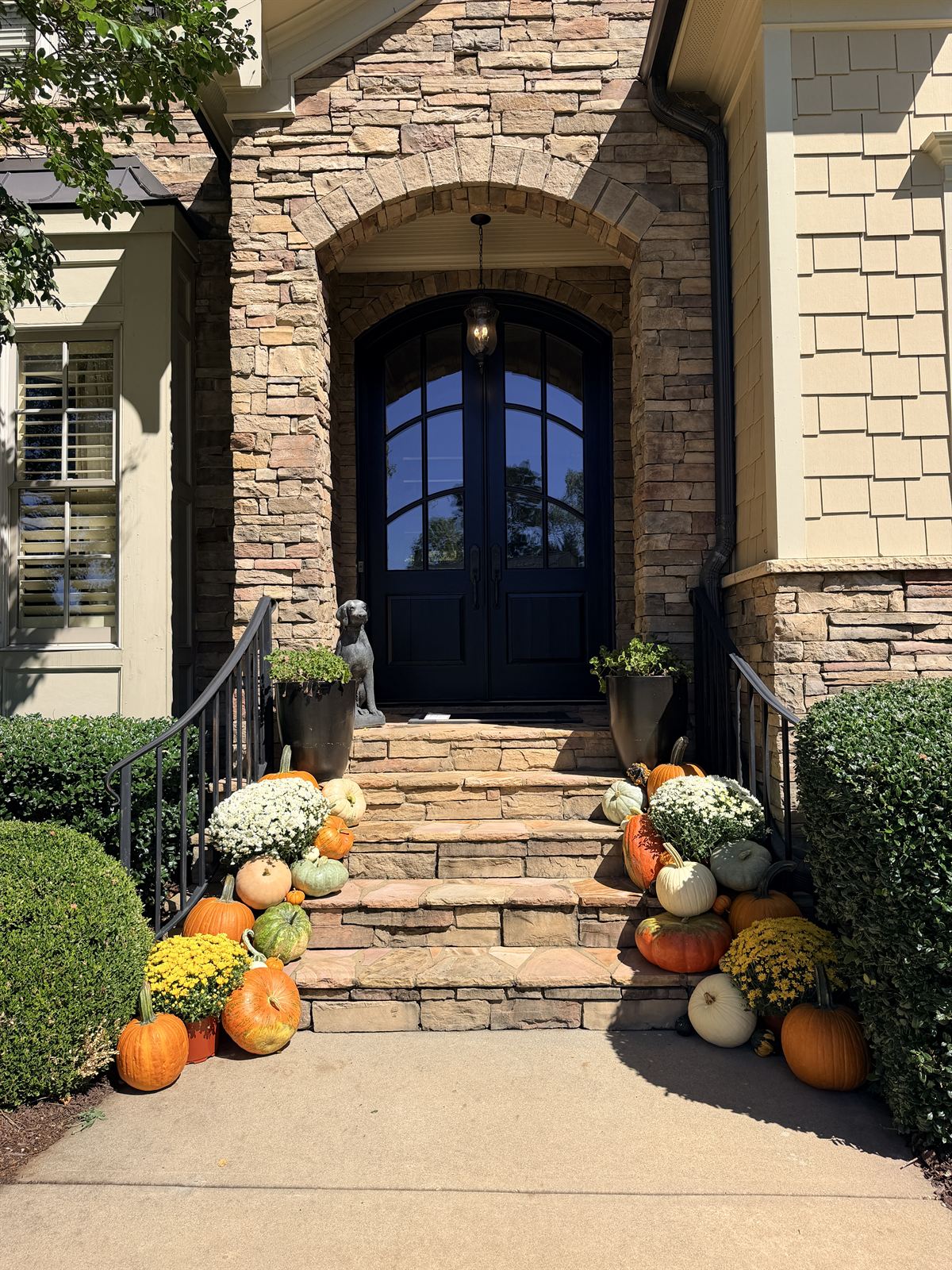 Stone entry steps styled with yellow and white mums and fall pumpkins, Triangle NC